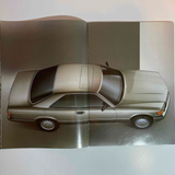 Book or magazine with a Mercedes-Benz 560 SEC car on a gray background